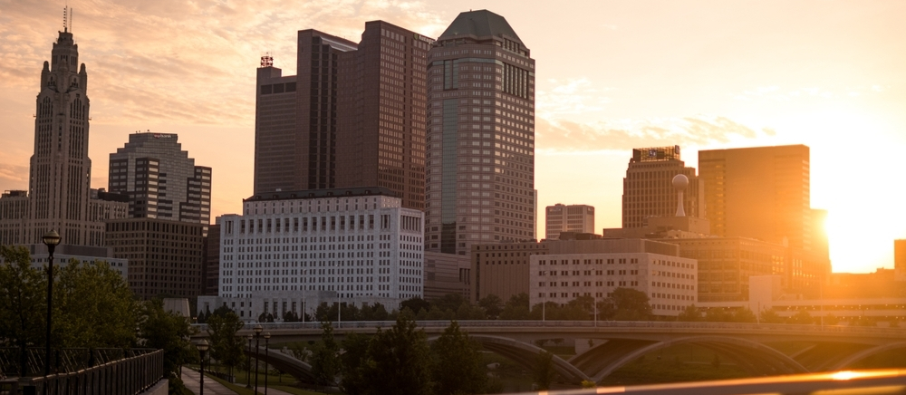 Downtown Columbus, Ohio skyline at sunset with the Scioto River pedestrian bridge in the foreground