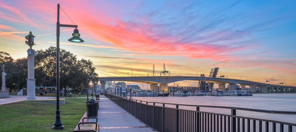 Jacksonville Riverwalk pathway at sunset overlooking the St. Johns River and Main Street Bridge