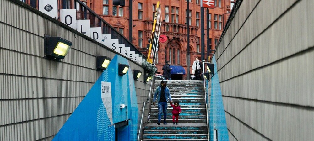 Parent and child walking down steps in London by Jack Bass