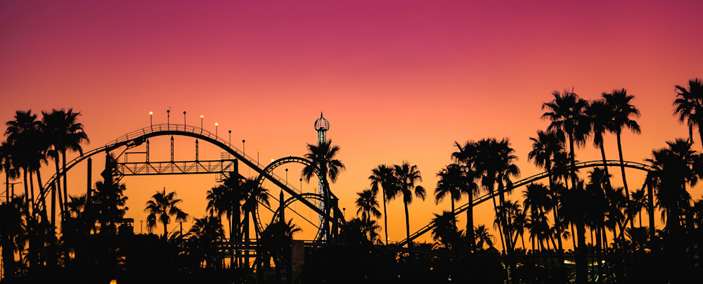 Roller coaster and palm trees against a sunset sky in Phoenix
